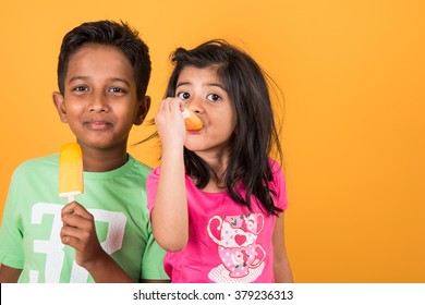 Indian/Asian Cute Kids Eating Ice Cream In Cone Or Candy. Isolated Over Colourful Background