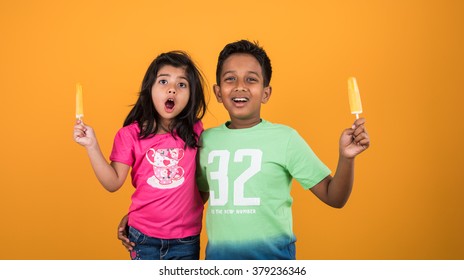 Indian/Asian Cute Kids Eating Ice Cream In Cone Or Candy. Isolated Over Colourful Background