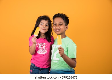 Indian/Asian Cute Little Kids Eating Ice Cream/mango Bar Or Candy. Isolated Over Colourful Background