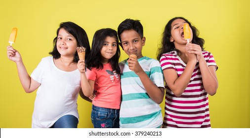 Indian/Asian Cute Little Kids Eating Ice Cream/mango Bar Or Candy. Isolated Over Colourful Background