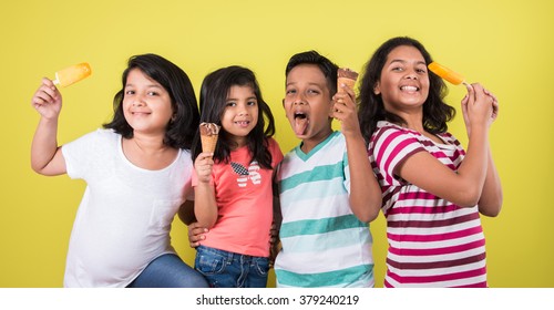 Indian/Asian Cute Little Kids Eating Ice Cream/mango Bar Or Candy. Isolated Over Colourful Background