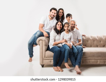 Indian/asian Family Sitting On Sofa Or Couch Over White Background