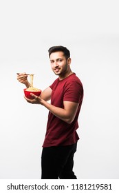 Indian/asian Man Eating Hot Noodles Or Ramen In A Red Bowl With Chopsticks