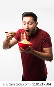 Indian/asian Man Eating Hot Noodles Or Ramen In A Red Bowl With Chopsticks