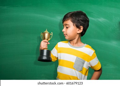 Indian/asian Small School Kid Holding Trophy Or Winning Cup