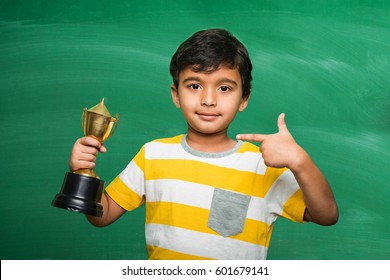 Indian/asian Small School Kid Holding Trophy Or Winning Cup, 