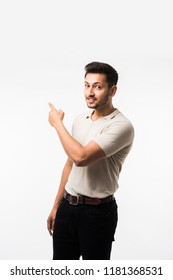 Indian/asian Young Man Pointing Something While Standing Isolated Over White Background With Copy Space