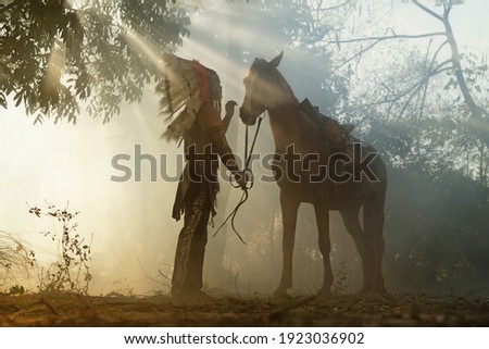 The Indians are riding a horse and spear ready to use In light of the Silhouette, American Indian warrior, chief of the tribe. man with feather he