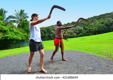 Indigenous Australian Man Teaches A Young Australian Woman How To Throw A Boomerang During Cultural Show In Queensland, Australia. Real People. Copy Space