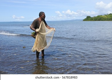 Indigenous Fijian Fisherman Fishing With A  Fishing Net In Vanua Levu, Fiji. Real People. Copy Space