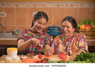 Indigenous Girl Chopping Tomatoes In The Company Of Her Grandmother, Enjoying The Moment.