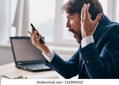 indignant man in suit looks at phone                               