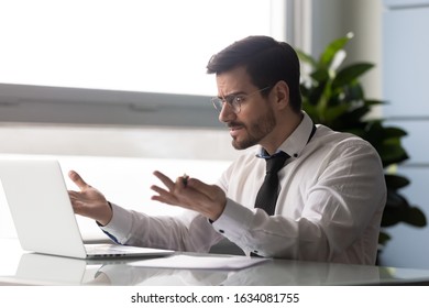 Indignant office worker seated at desk looks at pc screen having problems, results of long work are lost, deleted not saved, troubles with app, slow internet or computer, bad news by e-mail concept - Shutterstock ID 1634081755
