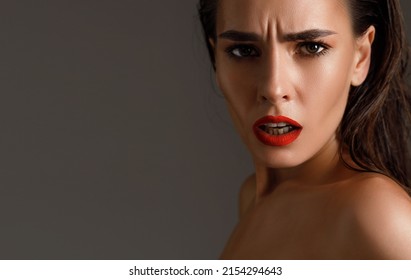 indignant and surprised glamor brunette woman with a wrinkle on her forehead, dissatisfied with aging and the appearance of wrinkles on her skin. Female with red lips and open mouth