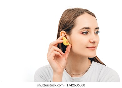 Individual Earplugs For Women. Woman Holding Customized Earplug Near The Ear, On White Background