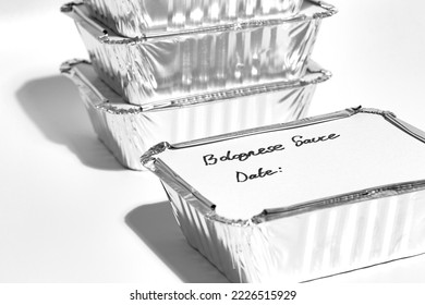 Individual foil tray containers filled with homemade bolognese sauce ready for freezing. Ideas for cutting the cost of food. - Shutterstock ID 2226515929