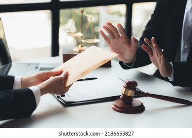 Individuals are giving bribes to officials in order to commit corruption in lawsuits, illegal actions by law enforcement by paying bribes to officials are illegal and unlawful. Fraud concept. - Shutterstock ID 2186653827