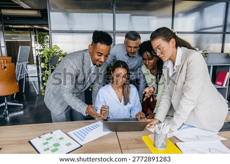 Individuals scrutinize printed graphs while engaging in discussion