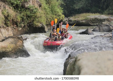 Indonesia - 06/24/2019. Group Of Happy People With Guide Whitewater Rafting And Rowing On Cisadane River, Bogor West Java Indonesia.