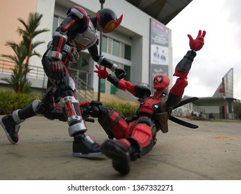 Indonesia - August 06, 2017 : Masked Rider figure and Deadpool playing outdoor in Park of Samarinda, Indonesia. Masked Rider is famous Television series in Japan and many country 