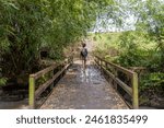 Indonesia, bali, female tourist walking on footbridge