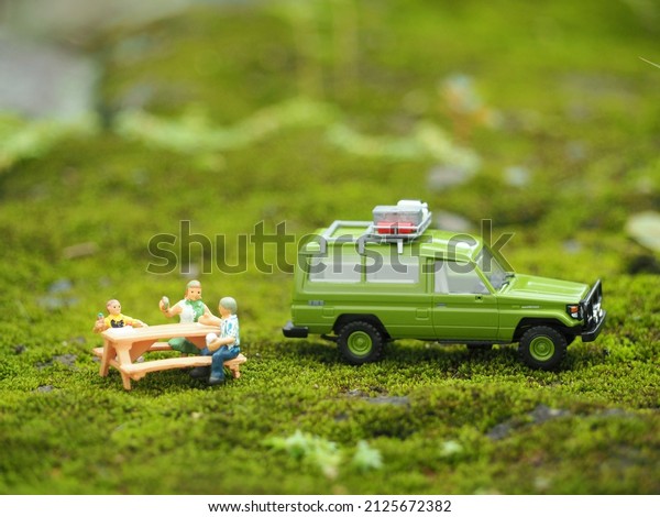 Indonesia - February 11, 2022 :\
Adventure, holiday and staycation conceptual design with mini toy.\
Blurred outdoor view on the green land. Conceptual\
photography.