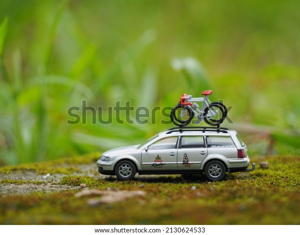 Indonesia - February 20, 2022 : Adventure, holiday\
and staycation conceptual design with mini car toy. Unfocus and\
blurred view at the green\
land.