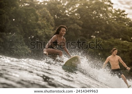Indonesia- java- happy woman and man surfing