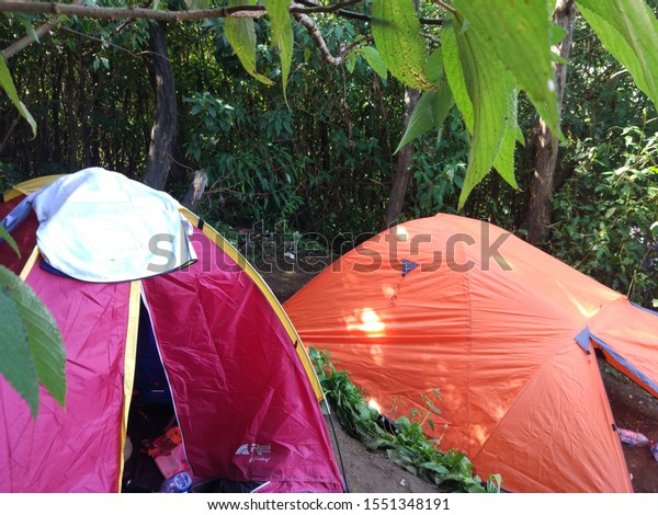 INDONESIA - JULY 08, 2017: Camping trip\
tent on holiday. Adventures Camping tourism and tent with beautiful\
sunrise in place for camping at Mount\
Slamet.