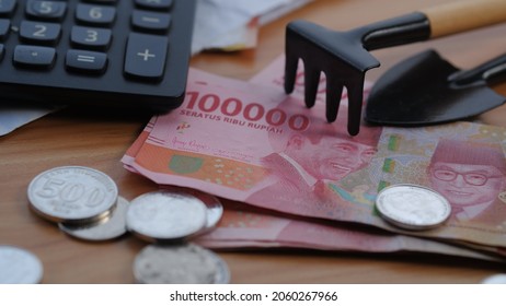Indonesia money, Rupiah, with shovel , pitchfork and calculator. financial and investment conceps, illegal online loan. Jakarta, 19 October 2021