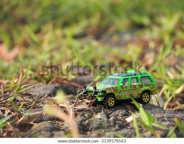 Indonesia - November 15, 2020 : Adventure,\
holiday and travelling conceptual design with mini toy. Blurred\
outdoor view. Unfocus stuff. Blurred green grass as a background.\
Conceptual\
photography.