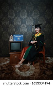 INDONESIA, Pontianak - January 29, 2020: Photo Studio - Beautiful Student Woman In Her Graduation Dress (Graduation Photo) 