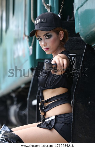 INDONESIA, PONTIANAK -\
March 20, 2020: Photographer / Model Photography - Beautiful sexy\
police-style female models and professional posture, photos of\
train cars\
(original)