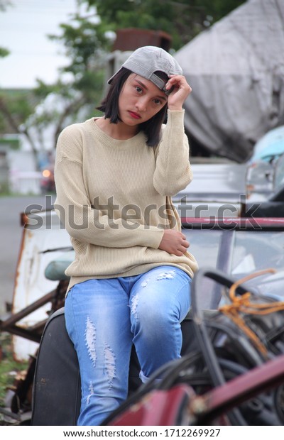 INDONESIA, PONTIANAK - March 20, 2020:\
Photographer / Model Photography - Beautiful funky-style woman,\
photoshoot in a used car shelter\
(original)