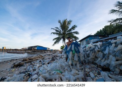 Indonesia, Tarakan City - 31 October 2021 : Portrait Of A Scavenger Collecting Plastic Bottles On The Coast Of Tarakan City