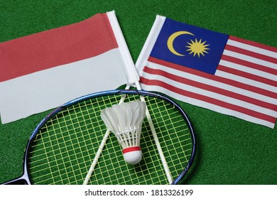 Indonesia Versus Malaysia Badminton Tournament Concept With Racket And Shuttlecock On The Flag Of Indonesia And Malaysia Background. Concept Of Badminton Tournament Between Countries.