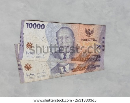 Indonesian 10000 Rupiah banknotes featuring Frans Kaisiepo on a marble background. Official currency used in Indonesia, symbolizing finance, economy, and national identity.