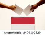 Indonesian election day.  election box with red and white flag.  hand inserts ballot paper into election box.  presidential and vice presidential elections in Indonesia