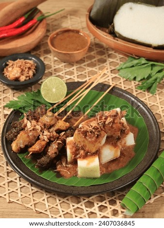 Indonesian famous food : sate ayam (chicken satay) , served with peanut sauce and rice cake or lontong
