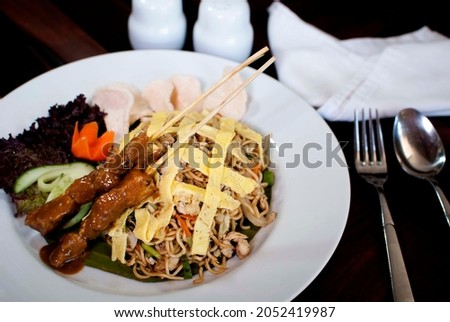  Indonesian famous “Mie Goreng”, fried Noodle served with chicken satay and omelet.