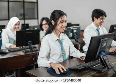 Indonesian female high school students smile while using a computer PC