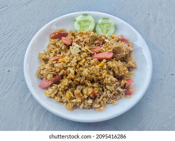 Indonesian fried rice with sausage and cucumber slices - Shutterstock ID 2095416286