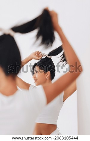 Indonesian girl with hair band. Focus on reflection in the mirror with silk scrunchies
