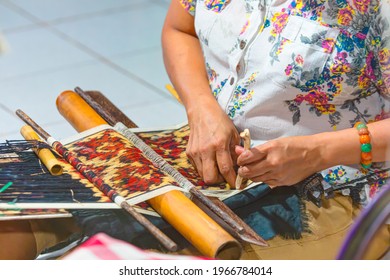 An Indonesian girl weaving traditional fabric - Bali, Indonesia - Powered by Shutterstock