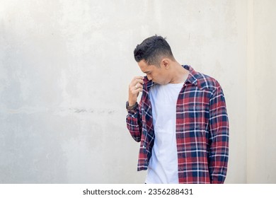 Indonesian man wear casual clothes smelling bad on his body. The photo is suitable to use for man expression advertising and fashion life style. - Powered by Shutterstock