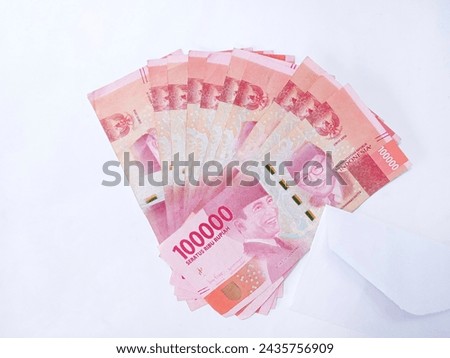 Indonesian money and a white envelope. Stack of Indonesian one hundred thousand rupiah banknotes isolated on white background. one million rupiah