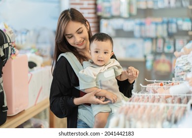 Indonesian Mother Shopping Clothes For Her Son In The Baby Boutique Store