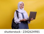 Indonesian senior high school muslim student smiling and holding laptop over yellow background
