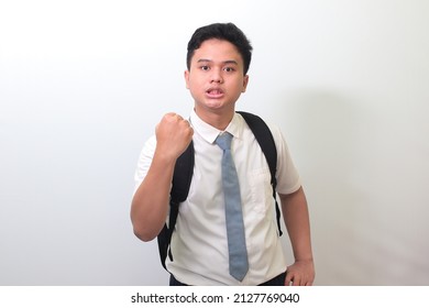 Indonesian Senior High School Student Wearing White Shirt Uniform With Gray Tie Trying To Punch With Fist. Bullying Concept. Isolated Image On White Background