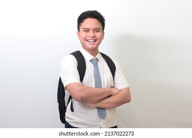 Indonesian Senior High School Student Wearing White Shirt Uniform With Gray Tie Keeping Arms Crossed And Looking At Camera. Isolated Image On White Background